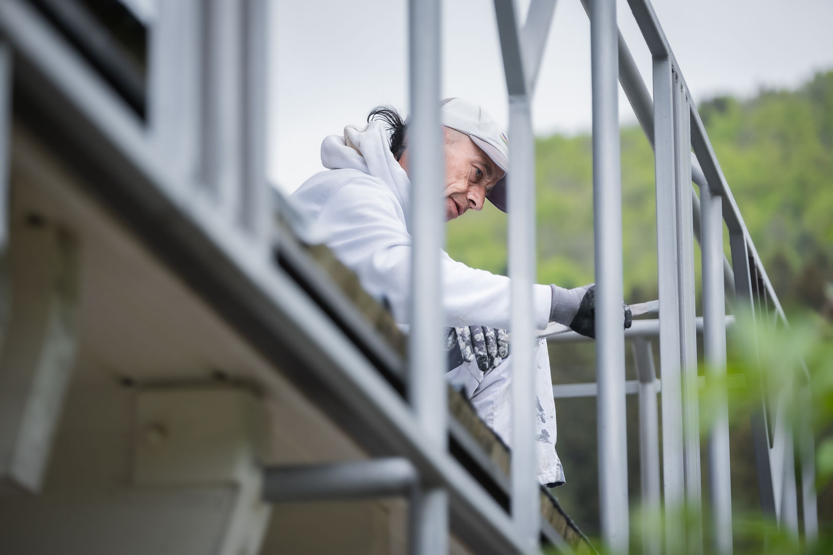 Maler lackiert ein Metallgeländer